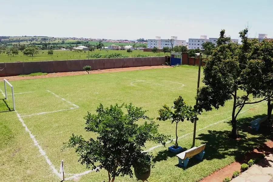 Área externa gramada com campo e árvores